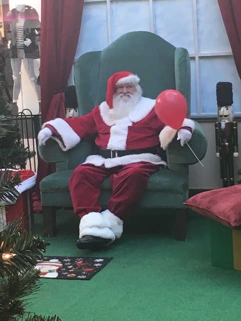 Santa waits for his next visitor. The balloon in his hand is a gift from the little boy who just left.