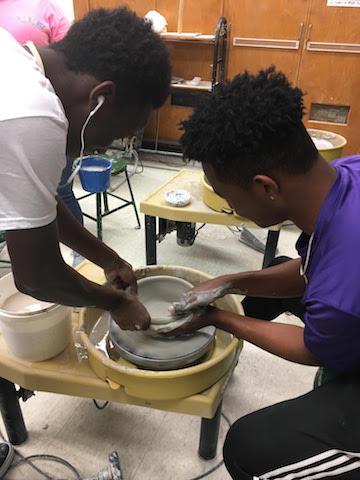 Ceramic students Lamar Lovelace and Rashod Bagby spinning clay into a bowl for their classes Lead to Feed project. 