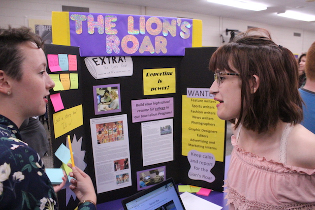 Editor+of+the+Lions+Roar%2C+Laura+Madler%2C+speaks+to+a+student+about+the+Lions+Roar+Club.